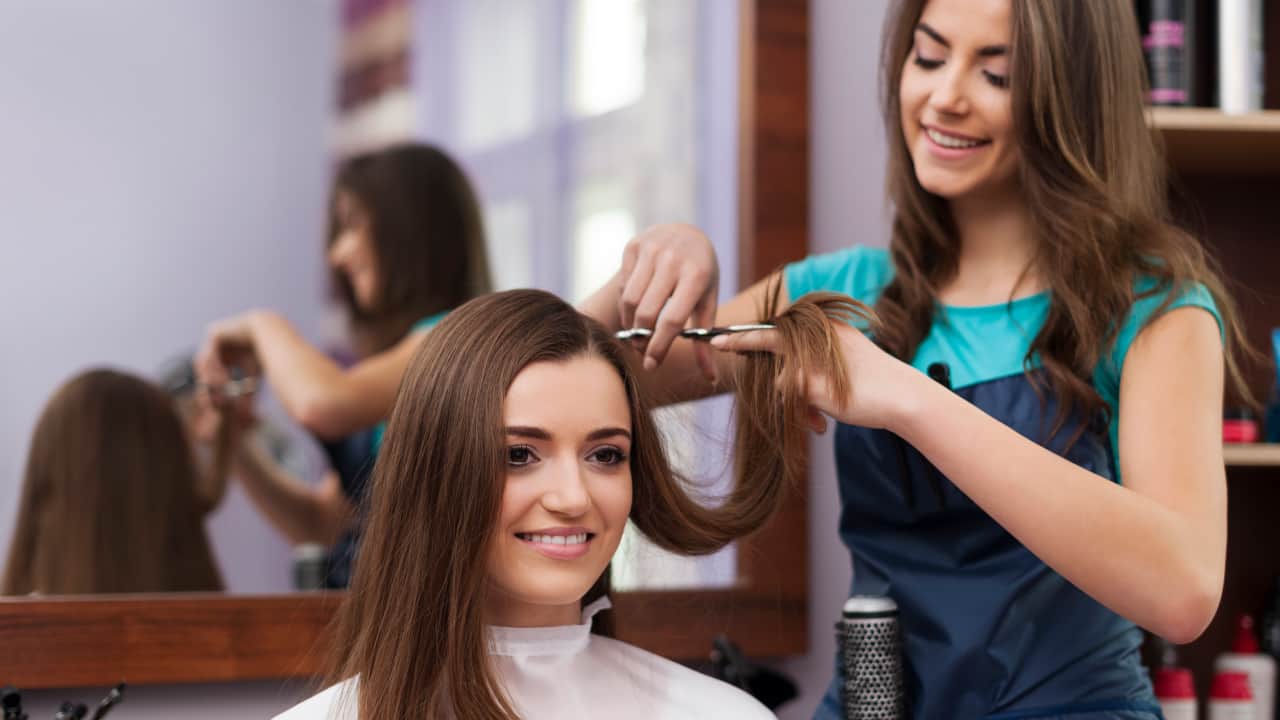 beautiful women has cutting hair which is necessary for bleached damaged hair