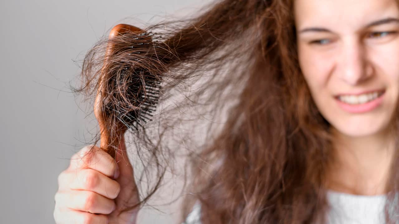 women struggling in brushing hair