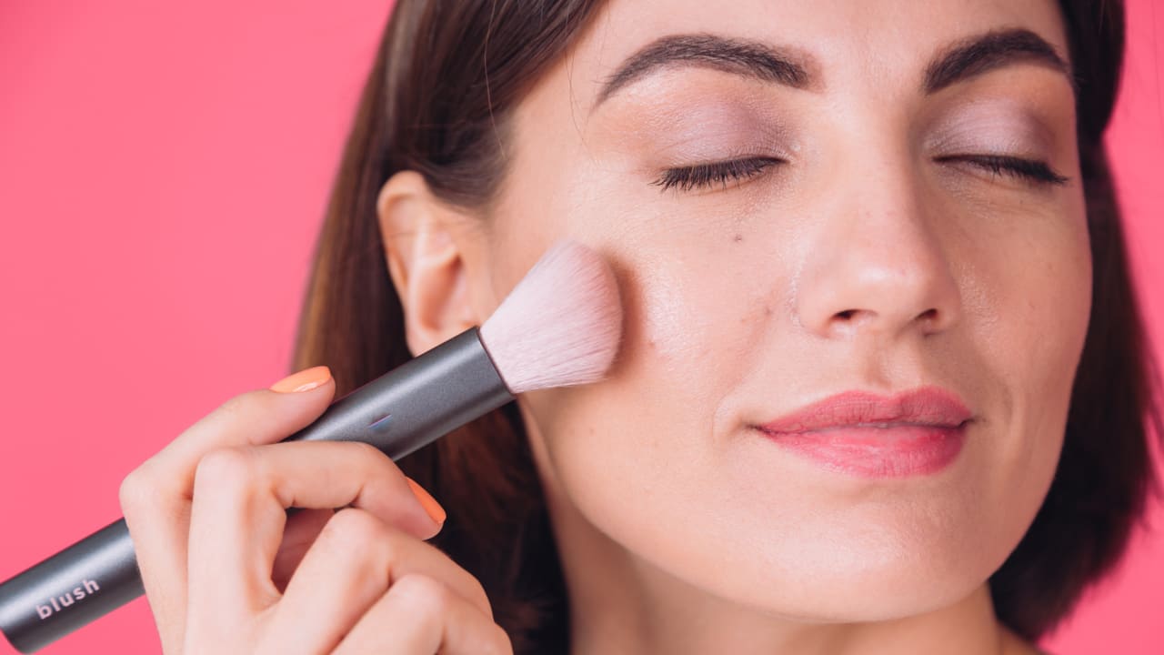 a lady applying blush-ons with a brush