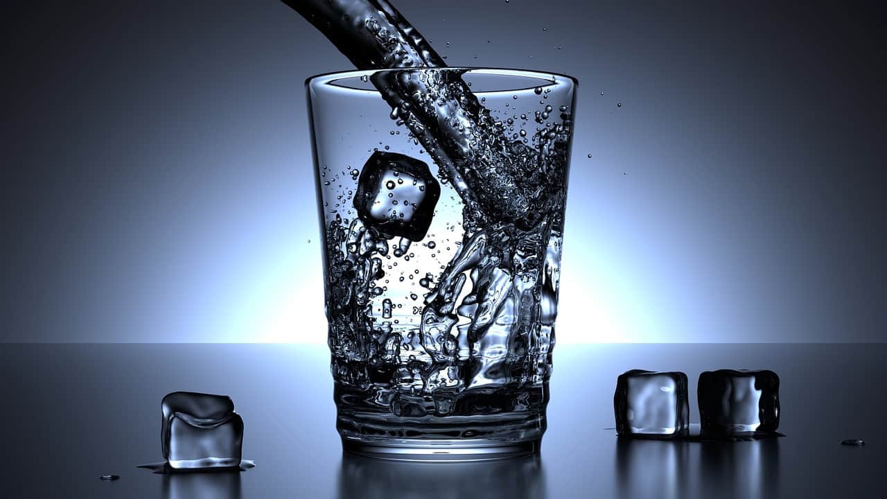 a glass filled with water and ice cubes